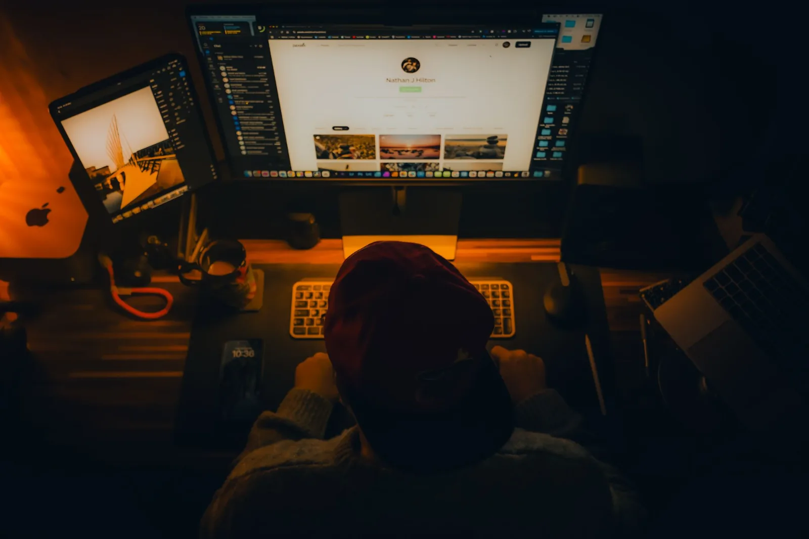 A web designer at a desk lit in warm light, working on a website